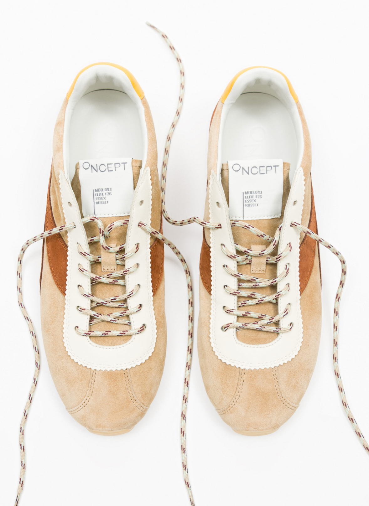 A pair of Concept brand low-top sneakers in beige suede and brown leather, featuring cream leather trim around the eyelets and tongue, and brown-and-white twisted rope laces, shown from a top-down view on a white background.