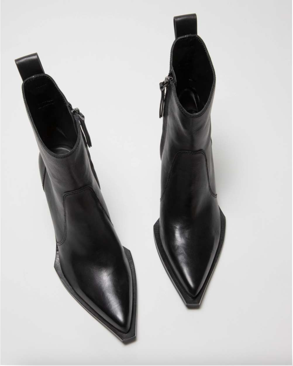 A pair of black leather pointed-toe ankle boots with side zippers, displayed on a clean light gray background.