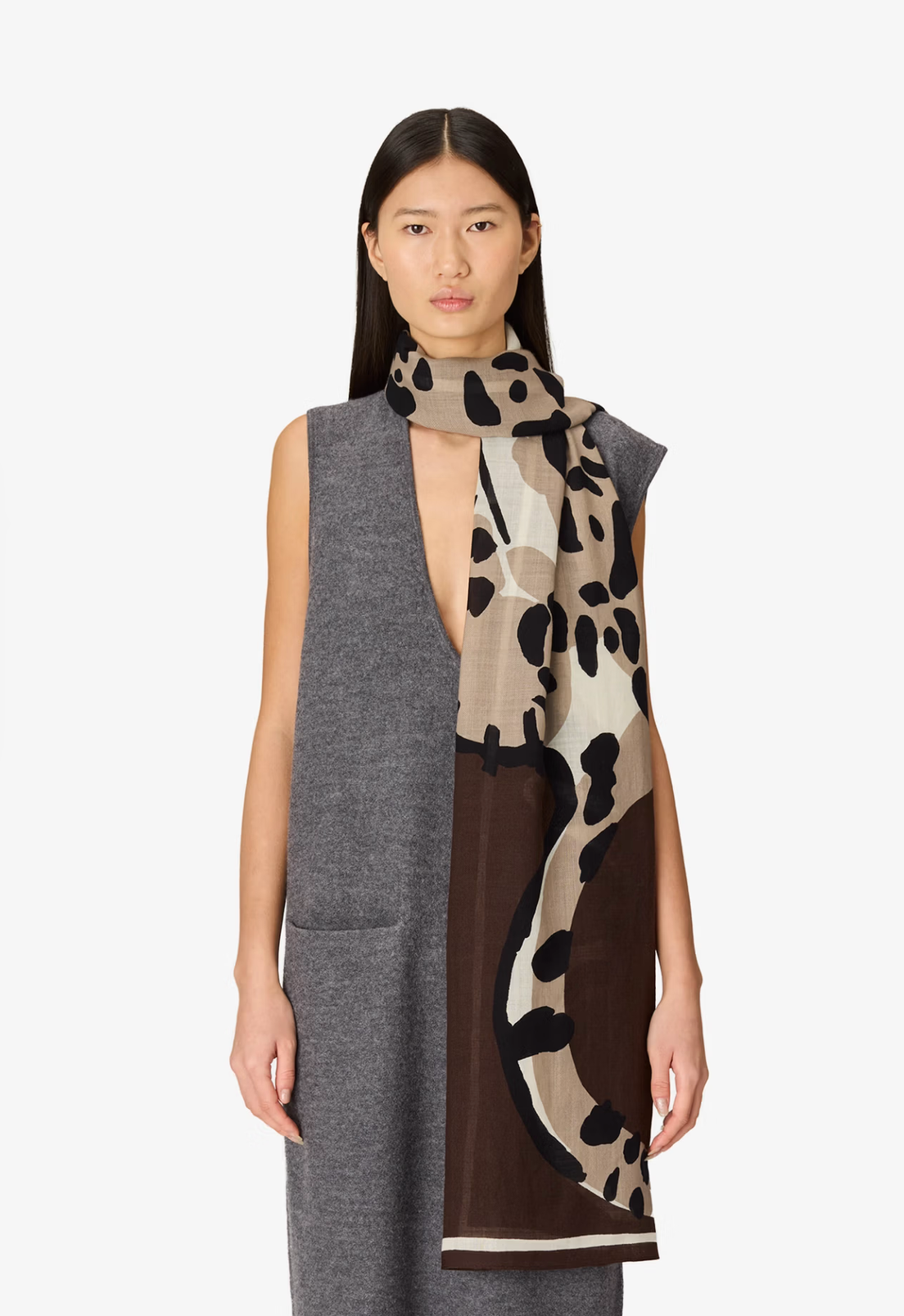 A model wearing a gray sleeveless dress and a blue patterned scarf with illustrations of cats, photographed against a plain light gray background.